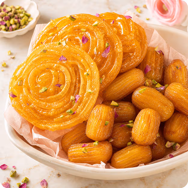 Zoulbia et Bamieh, pâtisseries frites au sirop de safran et d'eau de rose, parsemées de pistaches