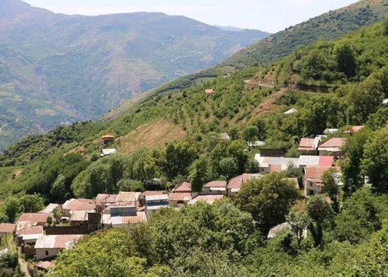 Village de Jirdeh : maisons aux toits de tuiles et de tôle au milieu de la forêt, sur un versant de montagne du Gilan